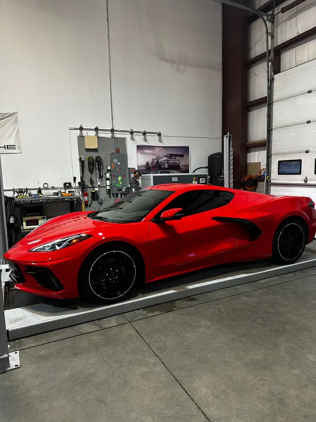 Red Corvette C8 on the drive-on lift