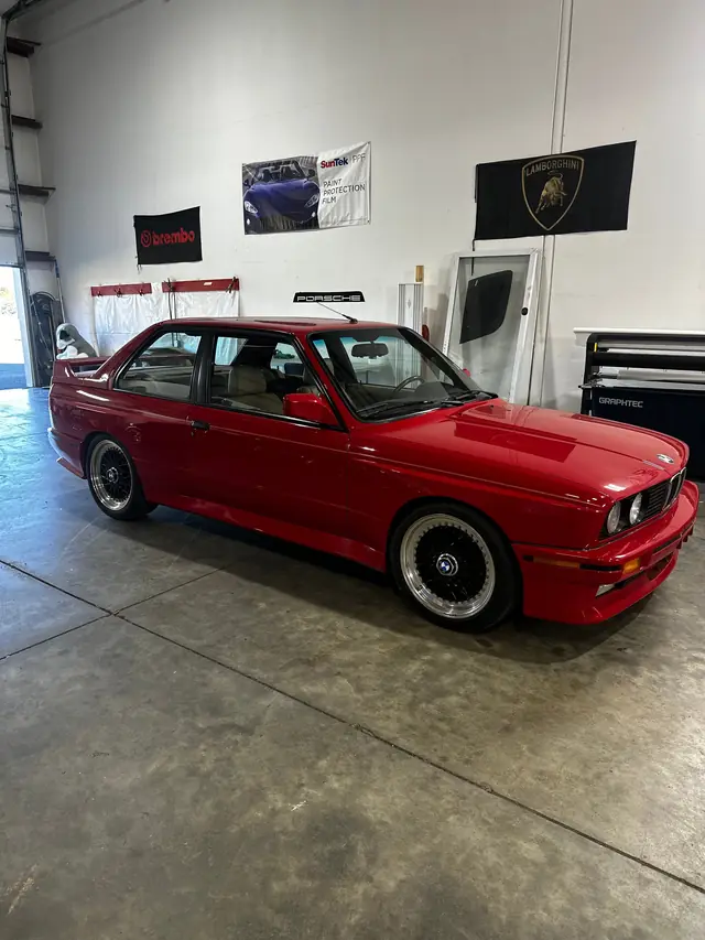 Red BMW E30 M3 in the shop, paint corrected to a deep gloss