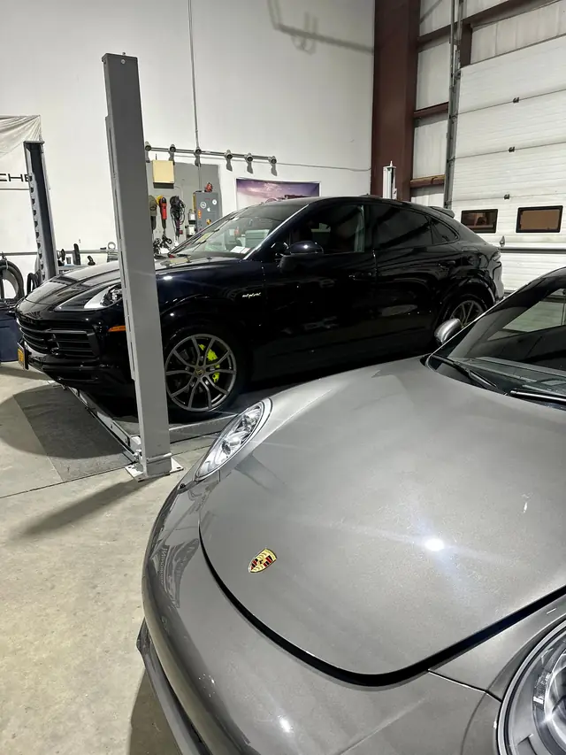 Grey Porsche front corner with a black Porsche behind